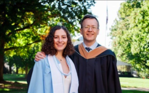 Father and daughter smile in academic regalia